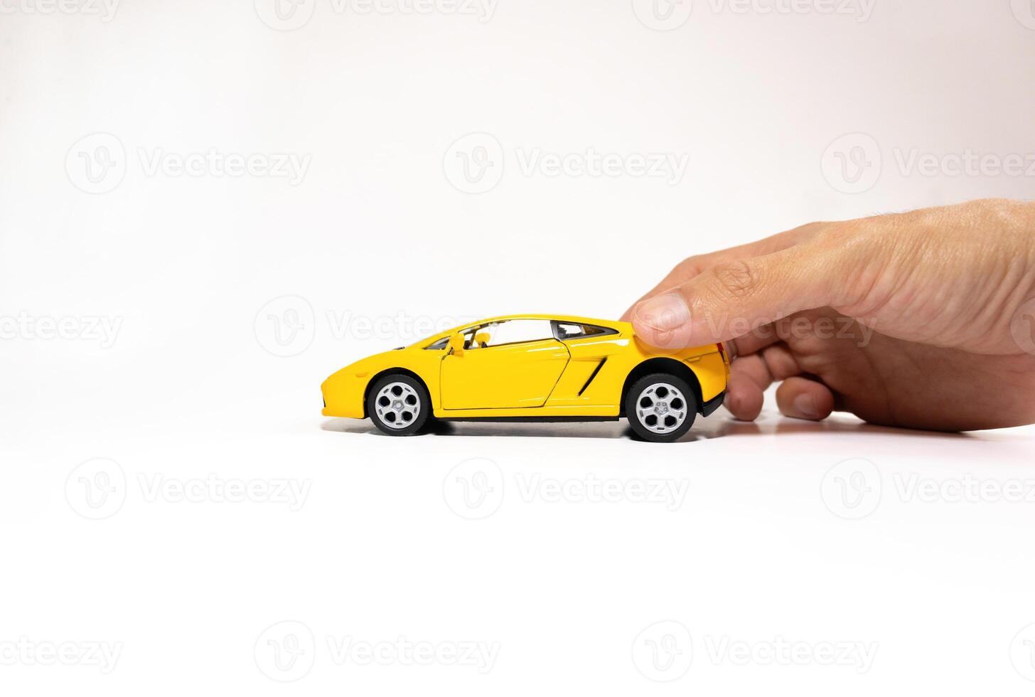 Hand holding a toy car isolated on white background. After some edits. photo