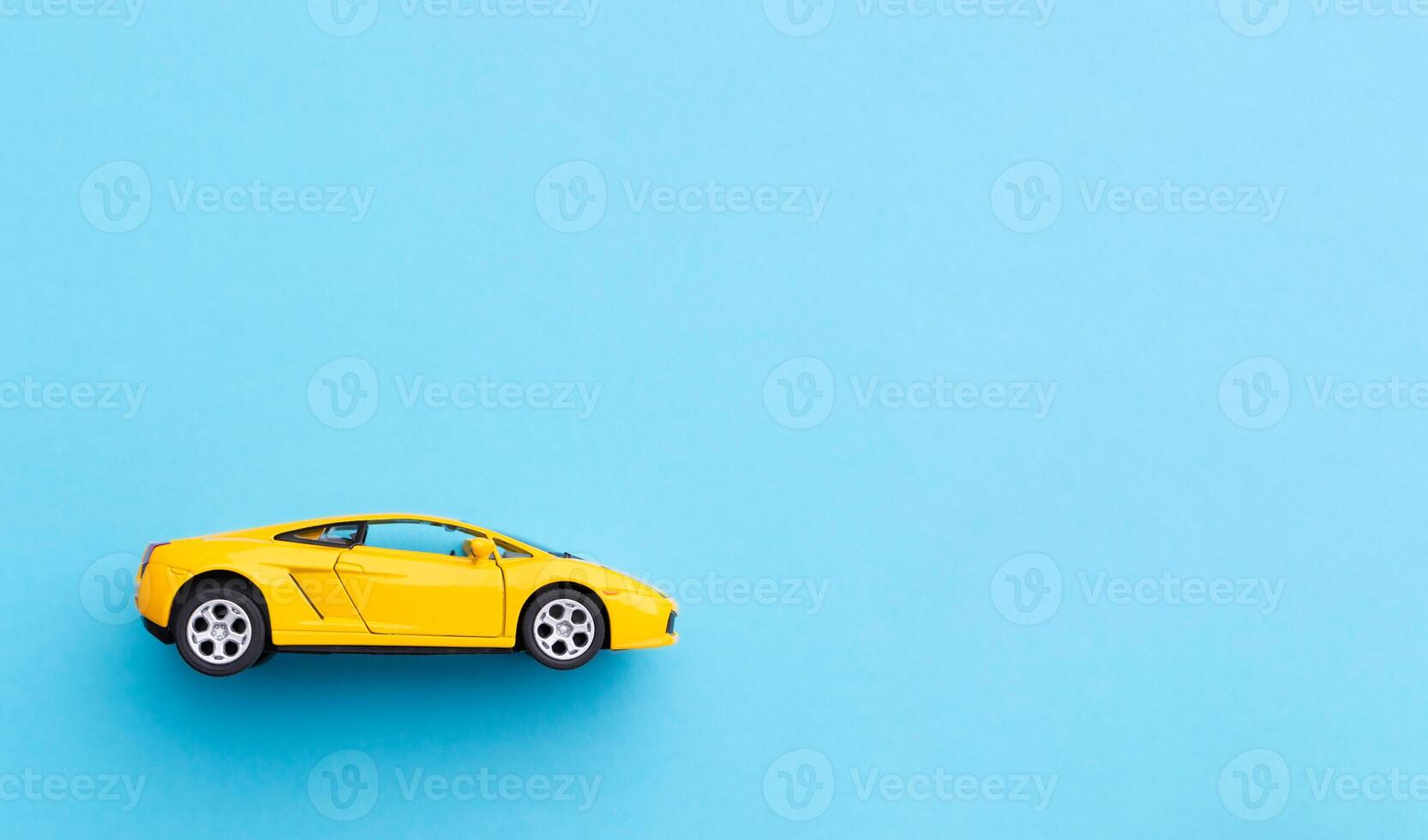 Yellow toy car isolated on blue background. After some edits. photo