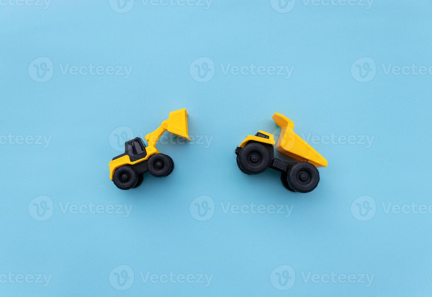 Miniature wheel loader and dump truck isolated on blue background. After some edits. photo