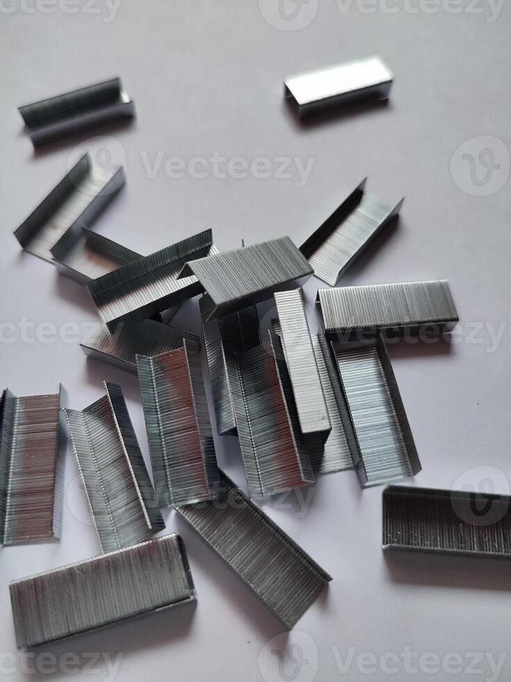 Close up stack of metal staples for stapler on a white background photo