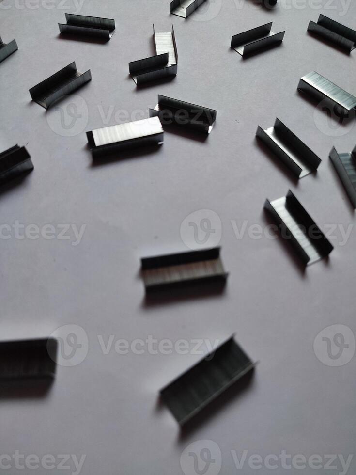 Close up stack of metal staples for stapler on a white background photo