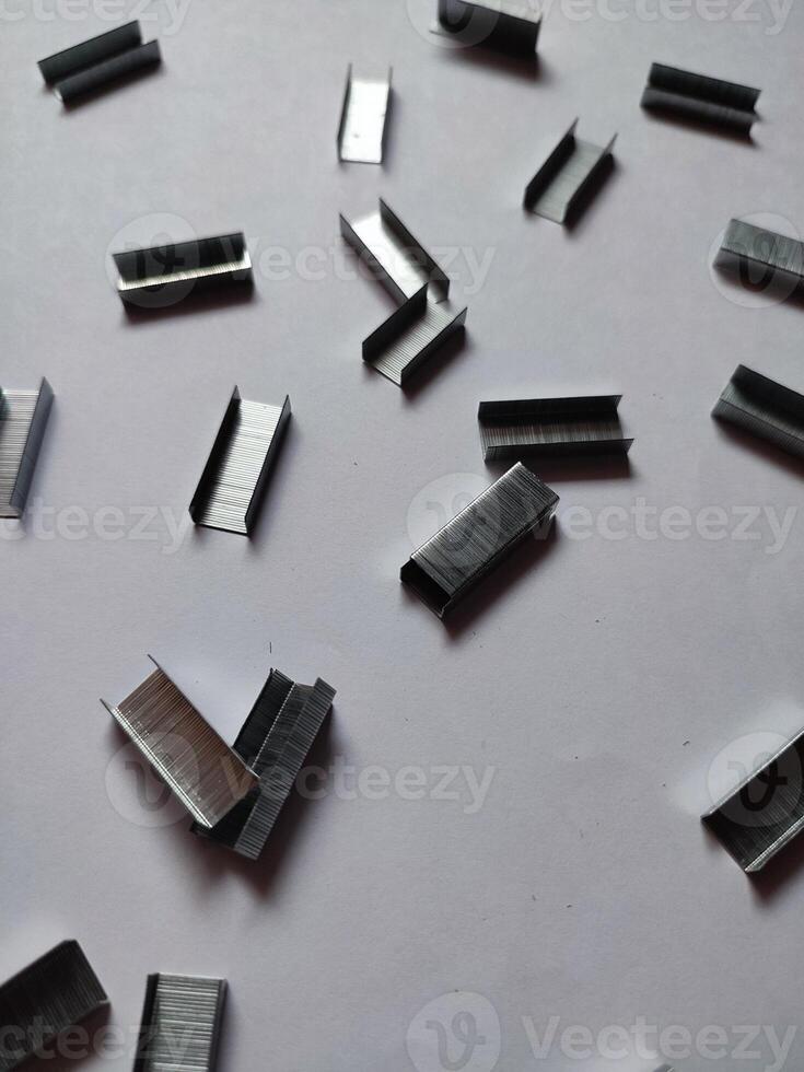 Close up stack of metal staples for stapler on a white background photo