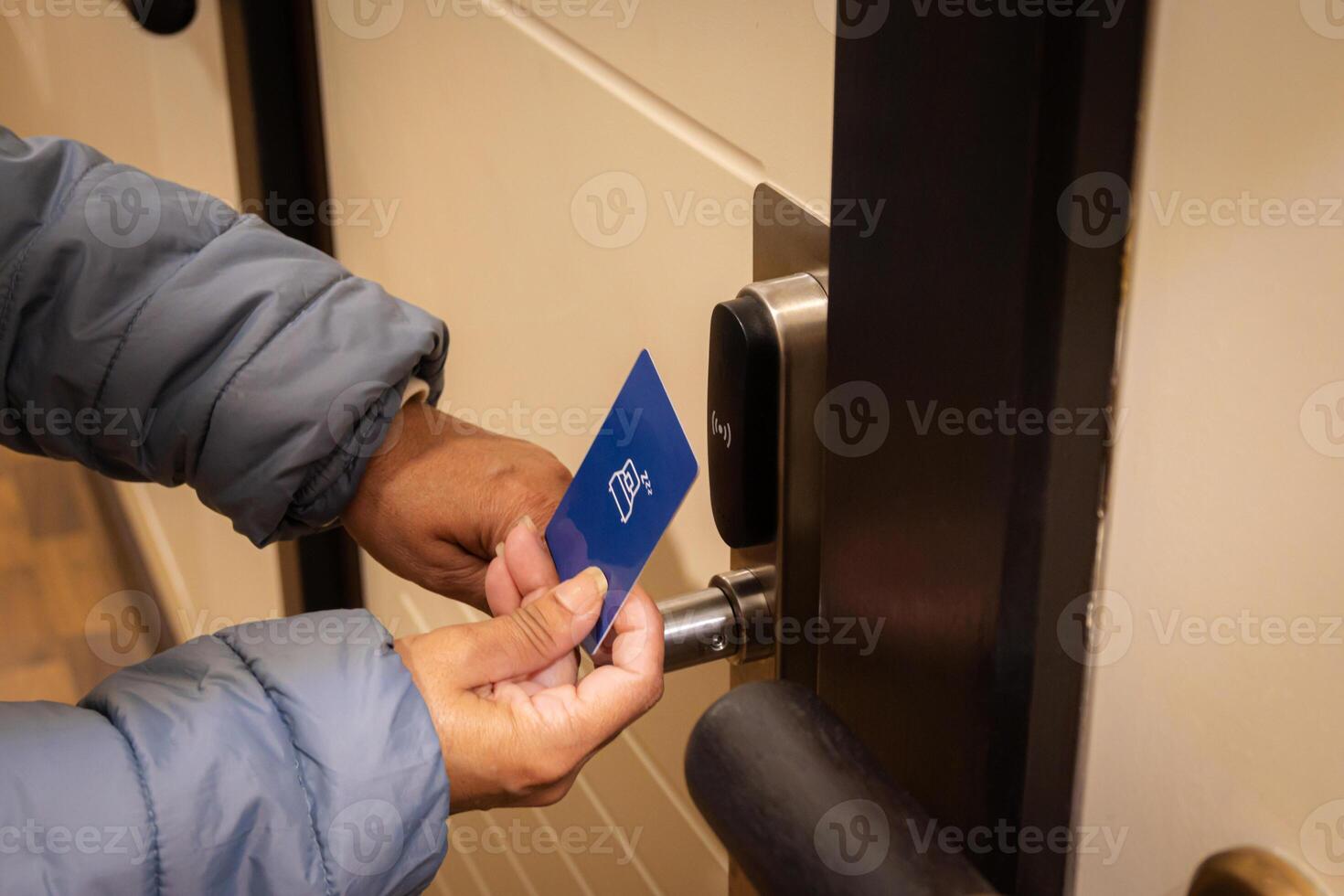 Woman hand using electronic smart key card to unlock door in hotel or house. Digital lock, door access control, contactless concept. Closeup, copy space photo