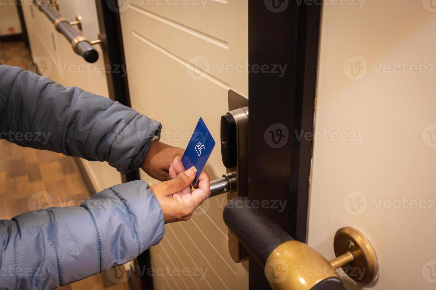 de cerca mano de joven latín mujer utilizando un tarjeta llave a desbloquear electrónico sensor de hotel puerta. seguridad concepto. foto