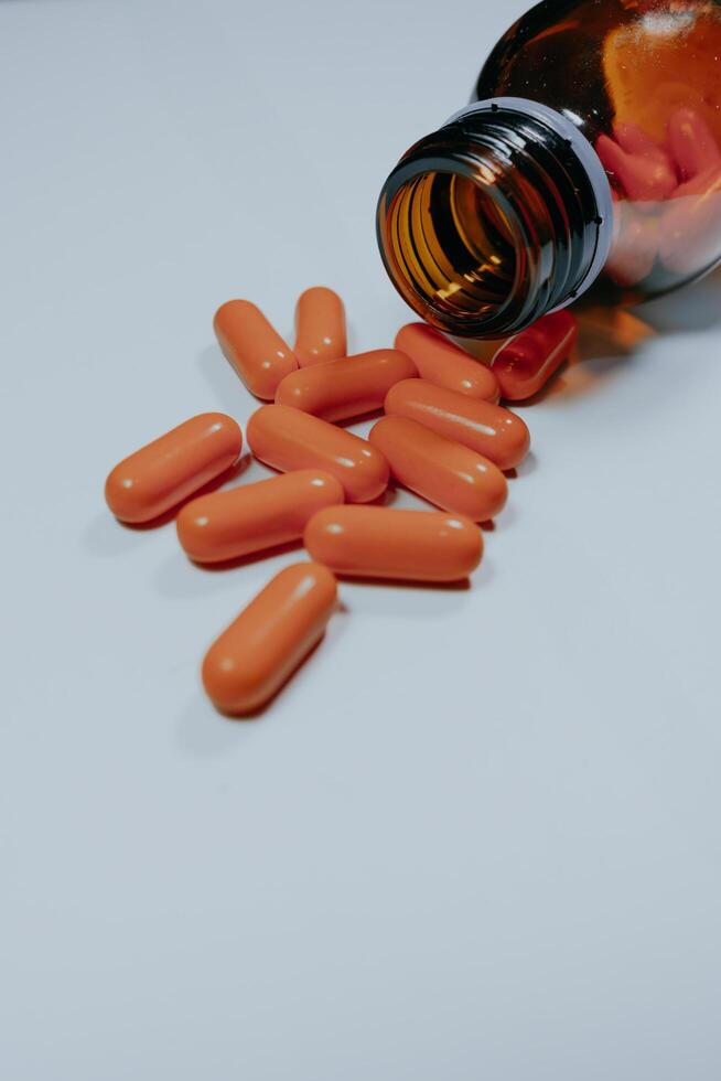Pill bottle spilled in surface isolated on white background. photo