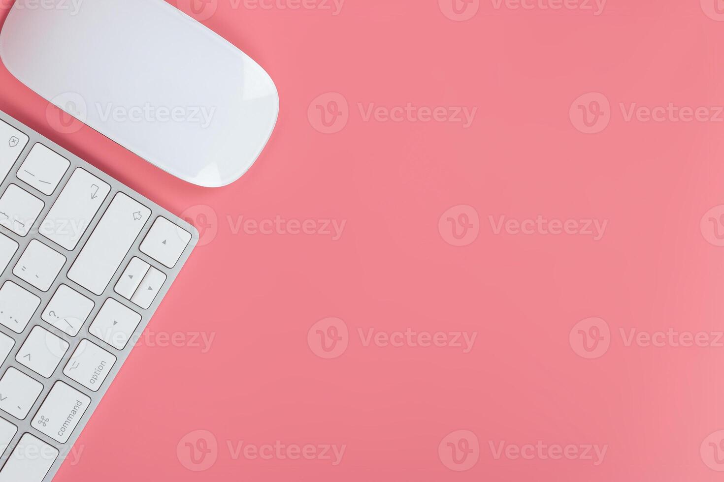 Flat lay, top view office table desk. Workspace with keyboard and mouse on pink background photo