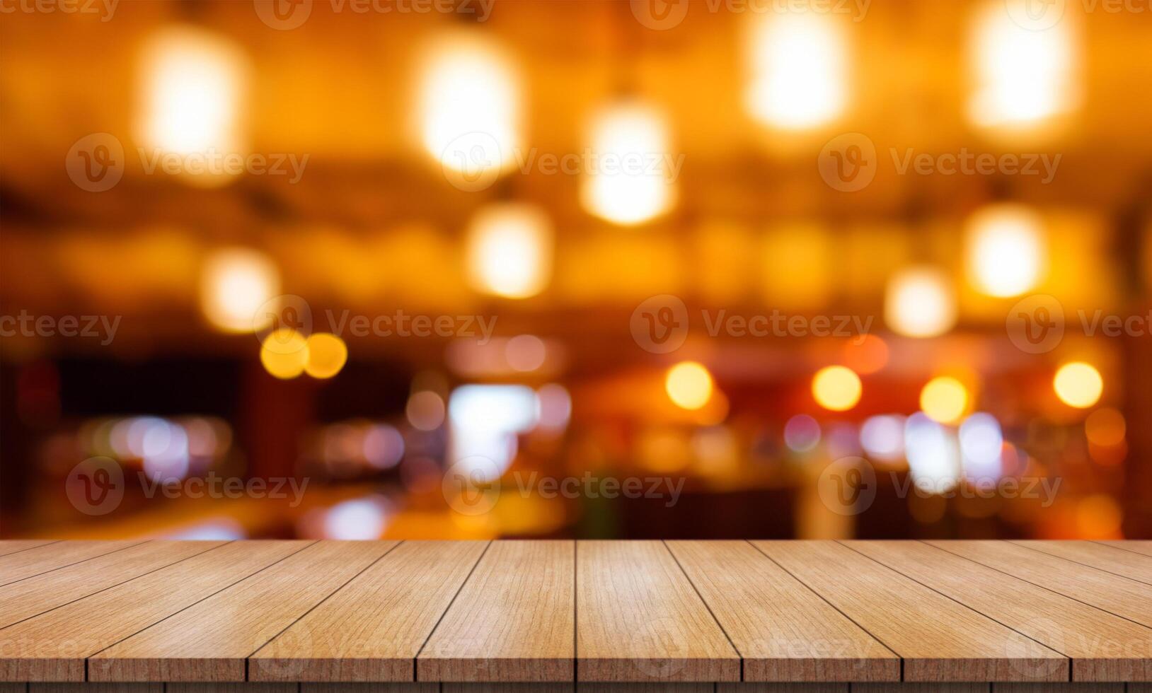 Empty wooden table top with lights bokeh on blur restaurant background. photo