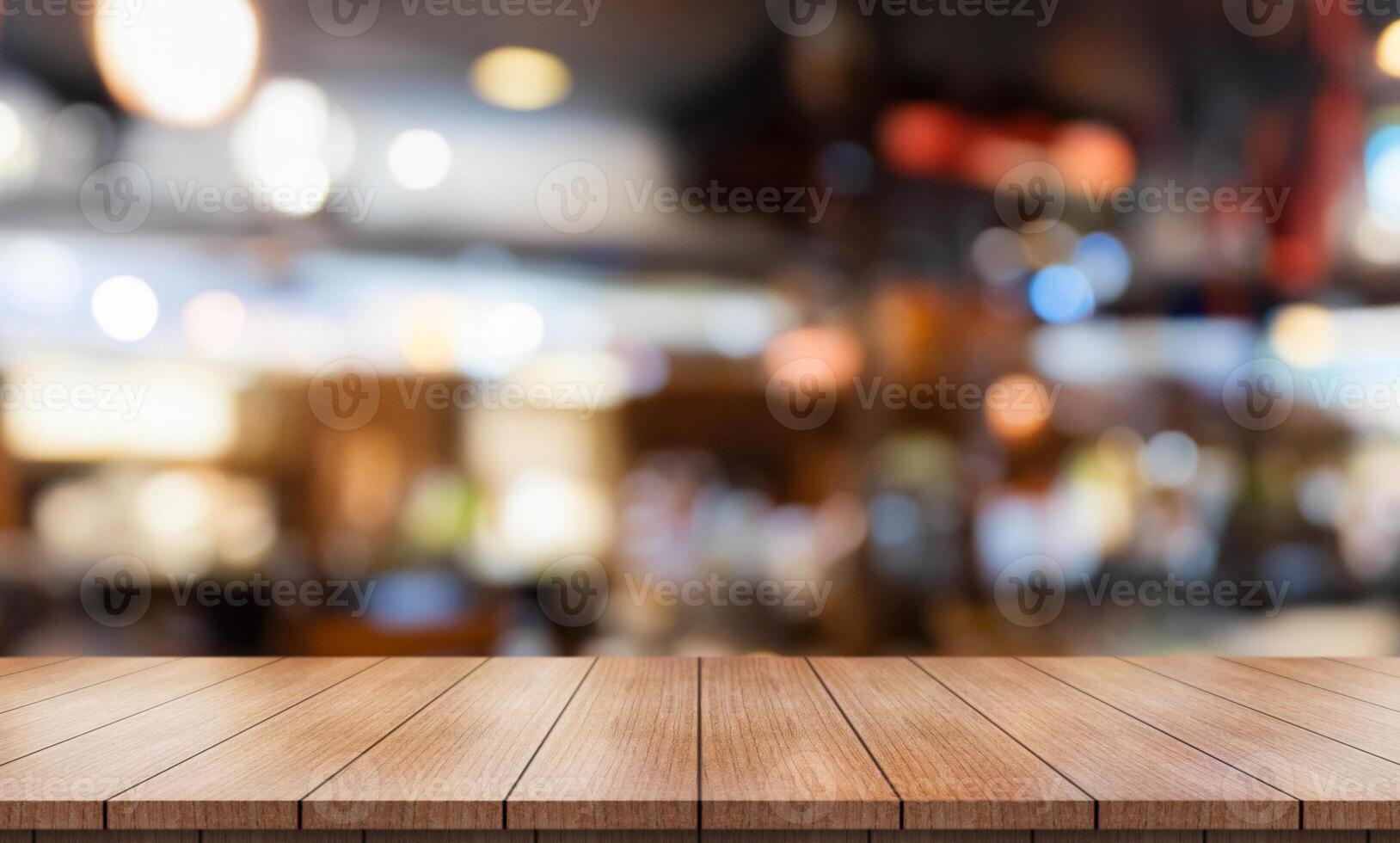 Empty wooden table top with lights bokeh on blur restaurant background. photo