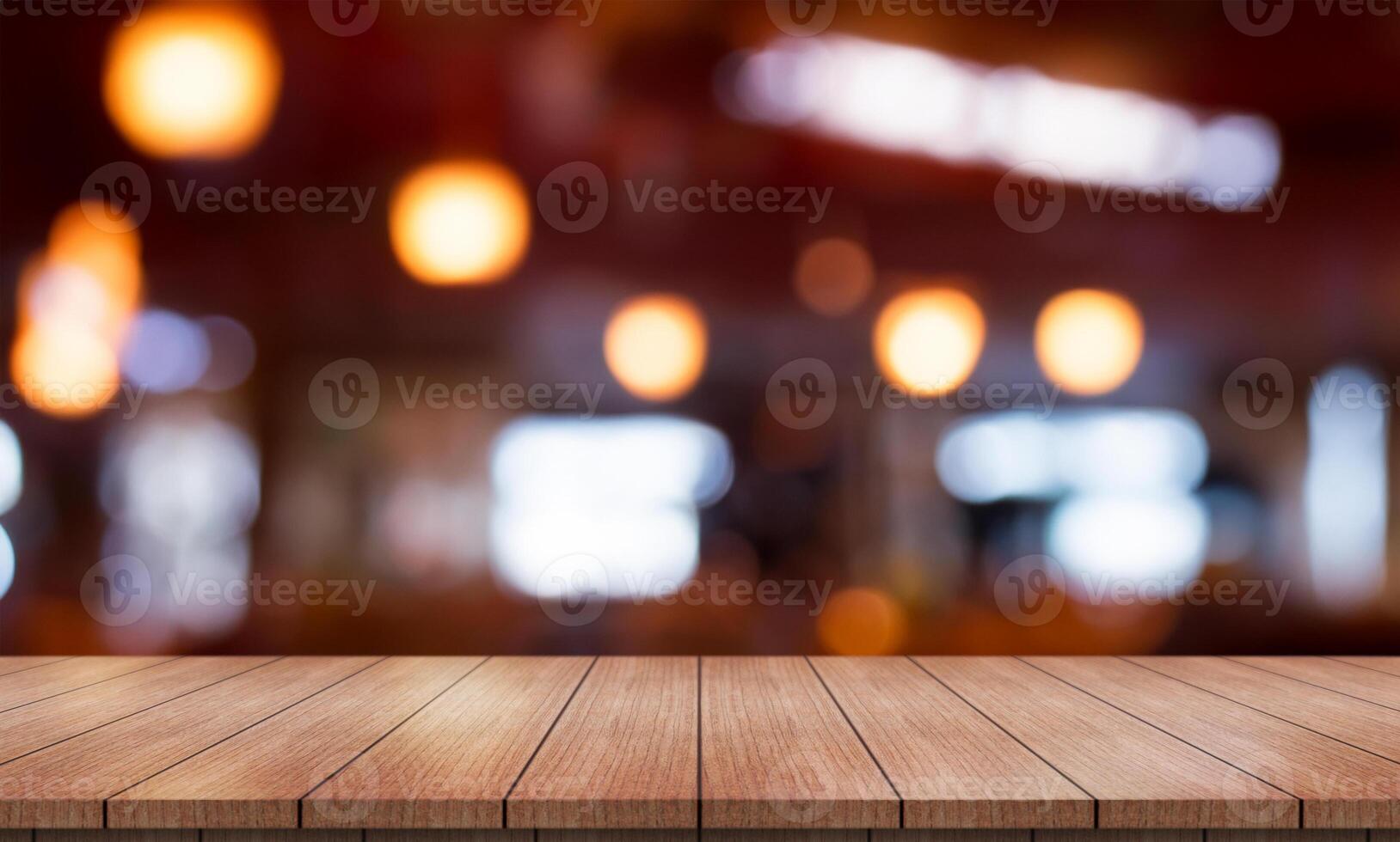 Empty wooden table top with lights bokeh on blur restaurant background. photo