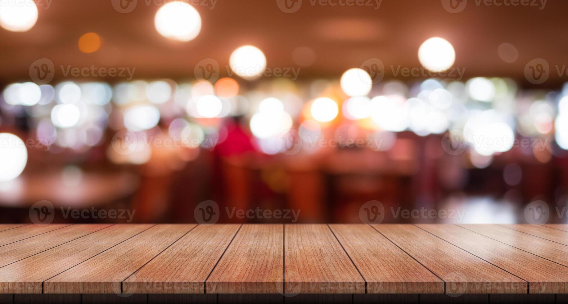 Empty wooden table top with lights bokeh on blur restaurant background. photo