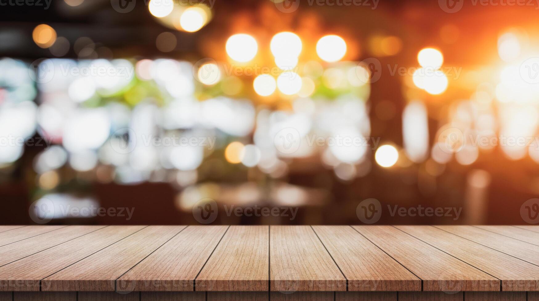 Empty wooden table top with lights bokeh on blur restaurant background. photo