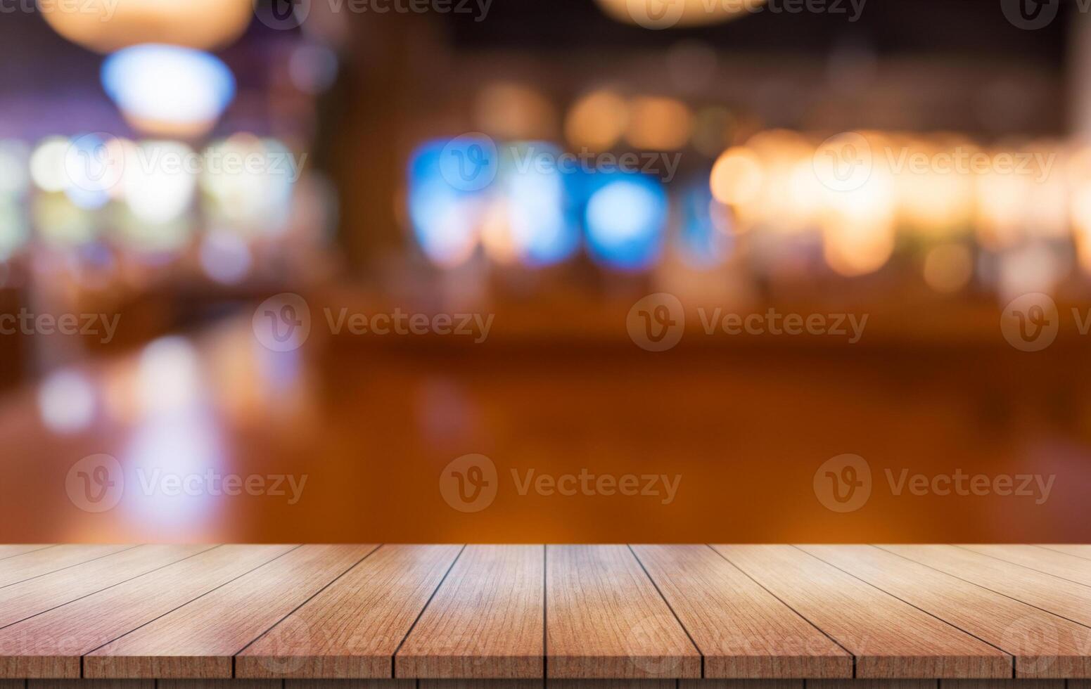 Empty wooden table top with lights bokeh on blur restaurant background. photo