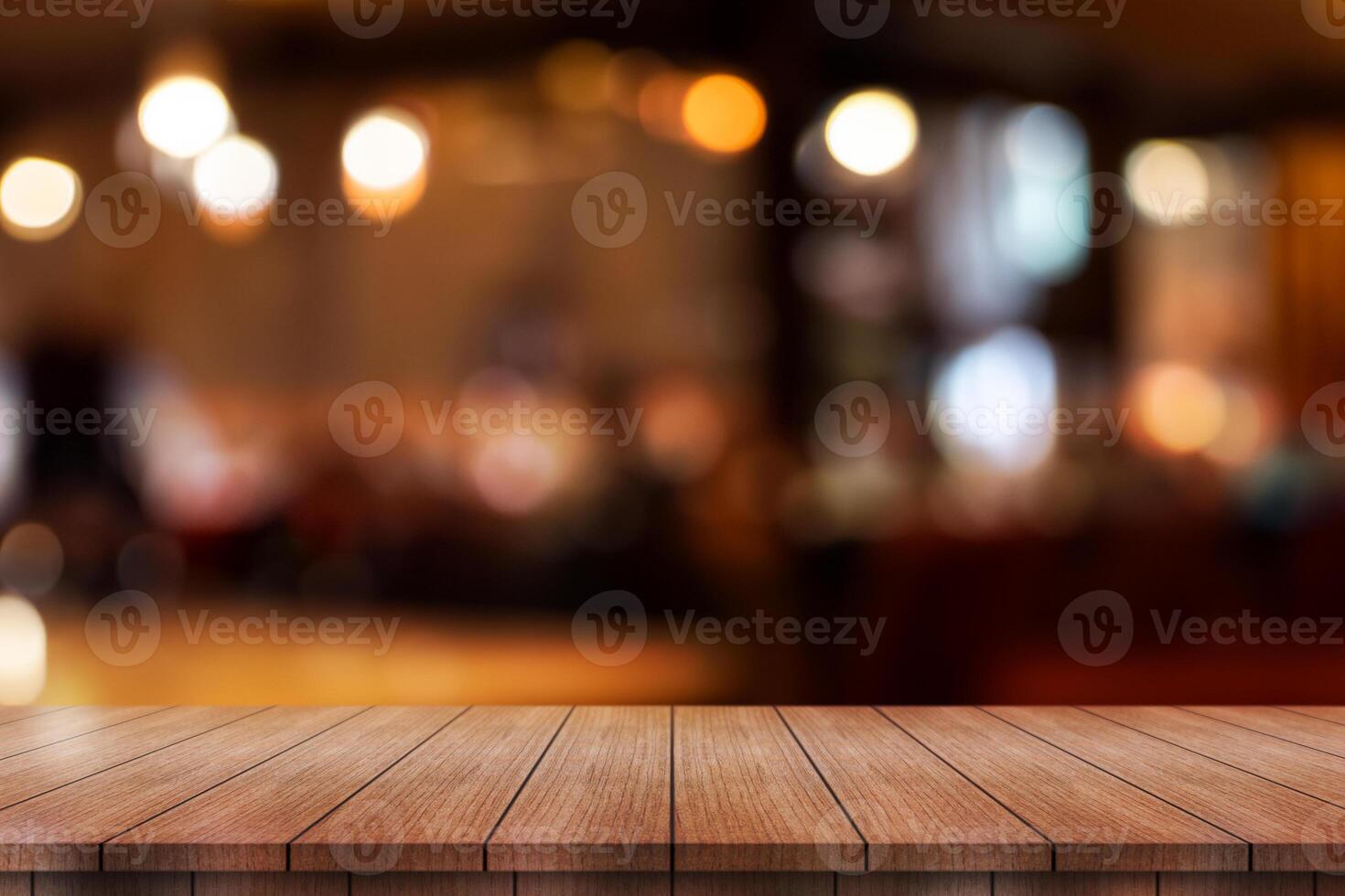 Empty wooden table top with lights bokeh on blur restaurant background. photo