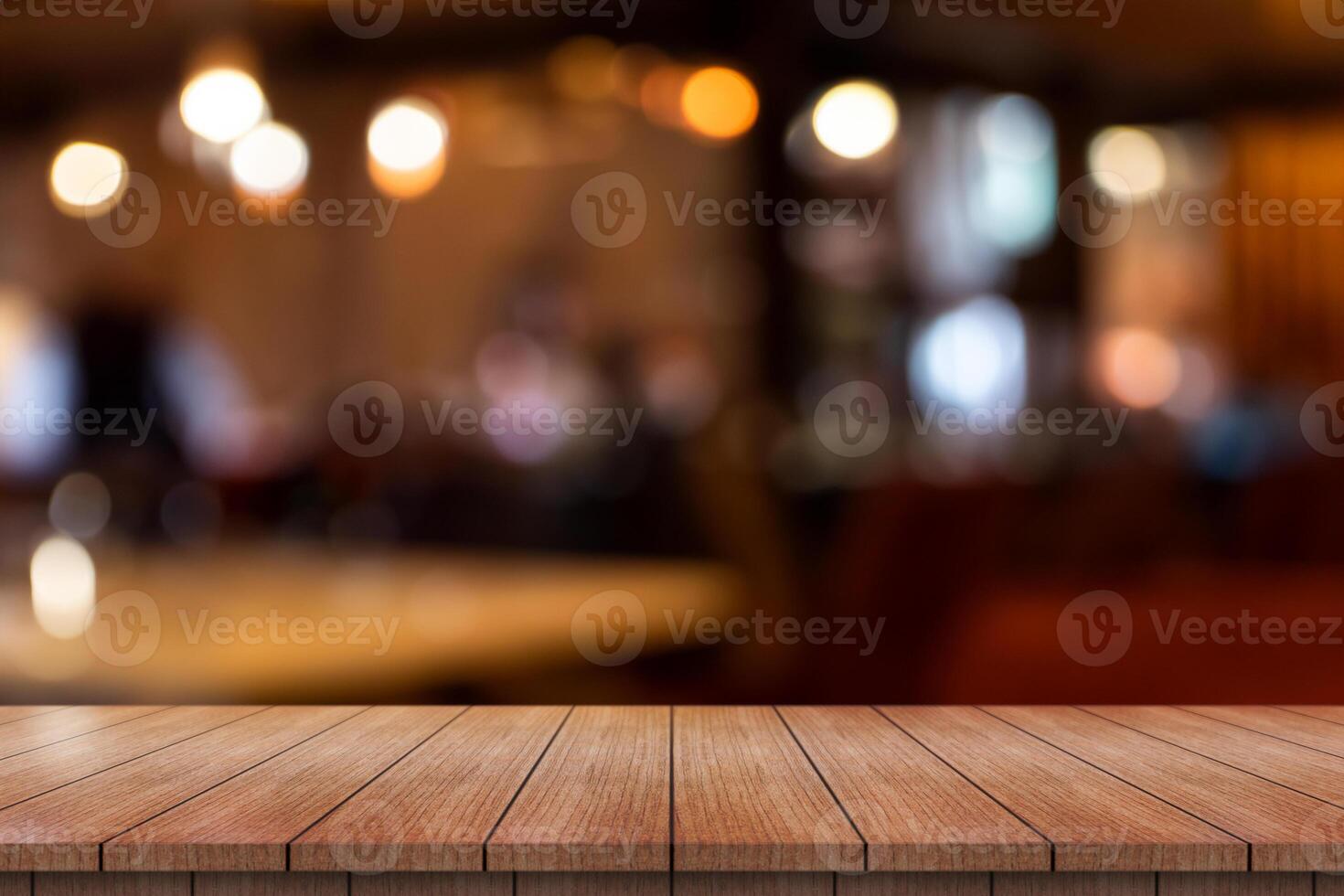 Empty wooden table top with lights bokeh on blur restaurant background. photo