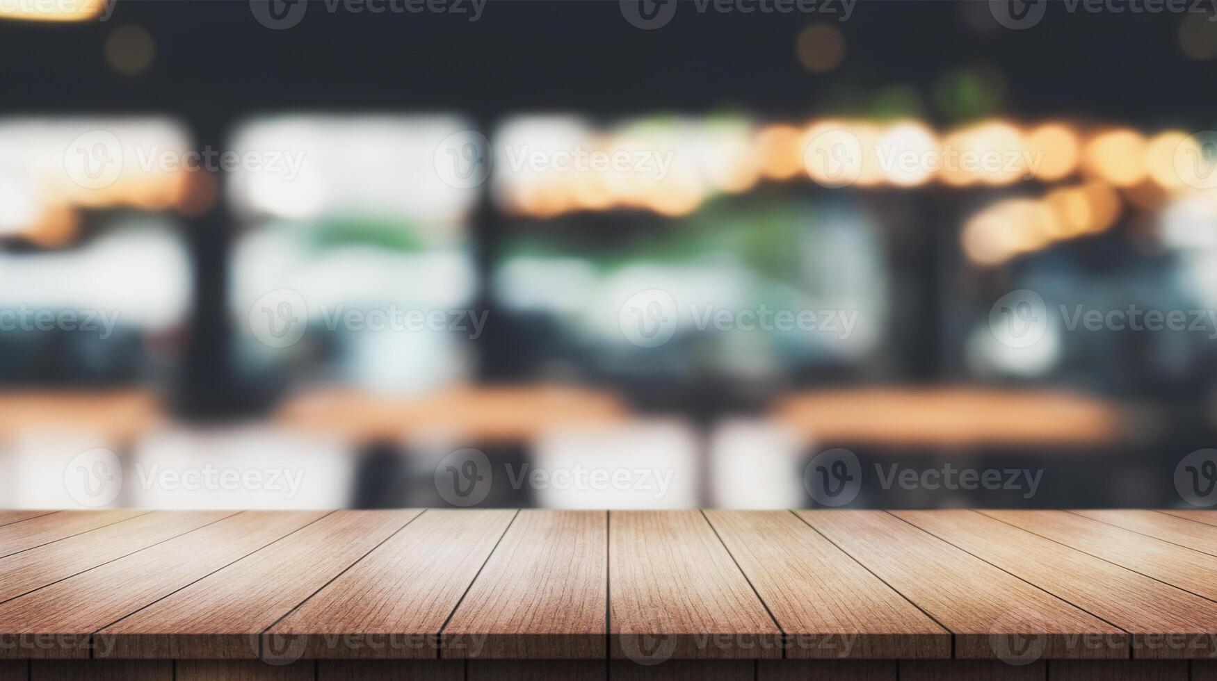 Empty wooden table top with lights bokeh on blur restaurant background. photo