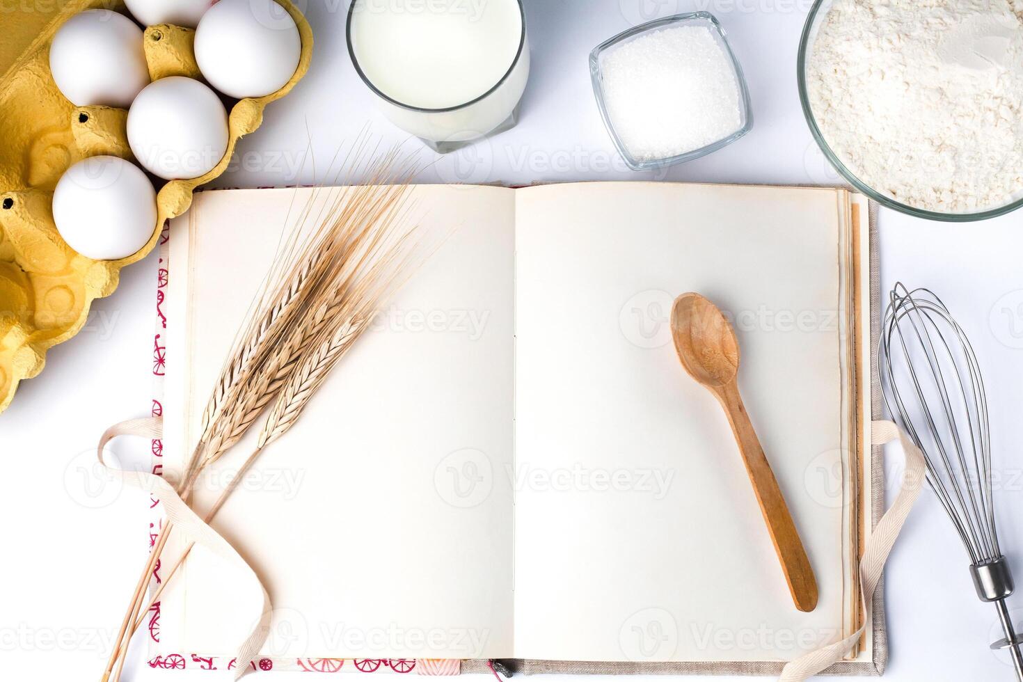 Blank vintage recipe book and ingredients for dough on the kitchen table. Close-up. Copy space. Top view. photo