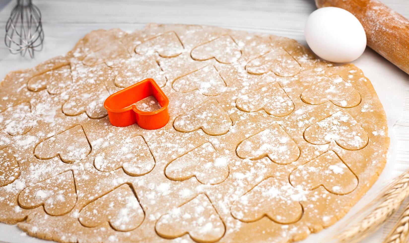 Homemade pastry. Cooking homemade cookies in the shape of a heart. Close-up. Top view. photo