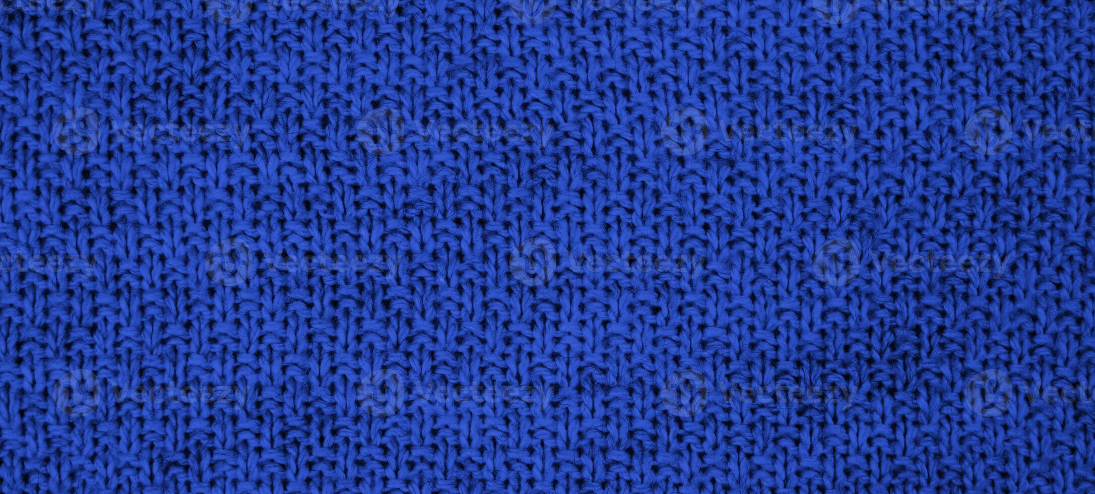 Texture of knitted wool fabric with of a blue color. Top view. Close-up. Banner. Selective focus. photo