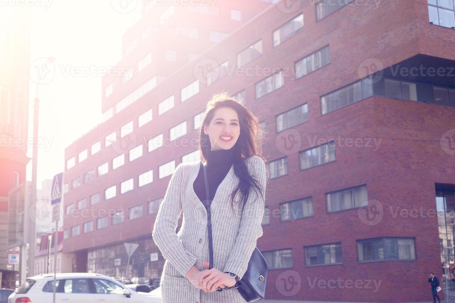 Young fashion brunette business woman against business center at sunset photo