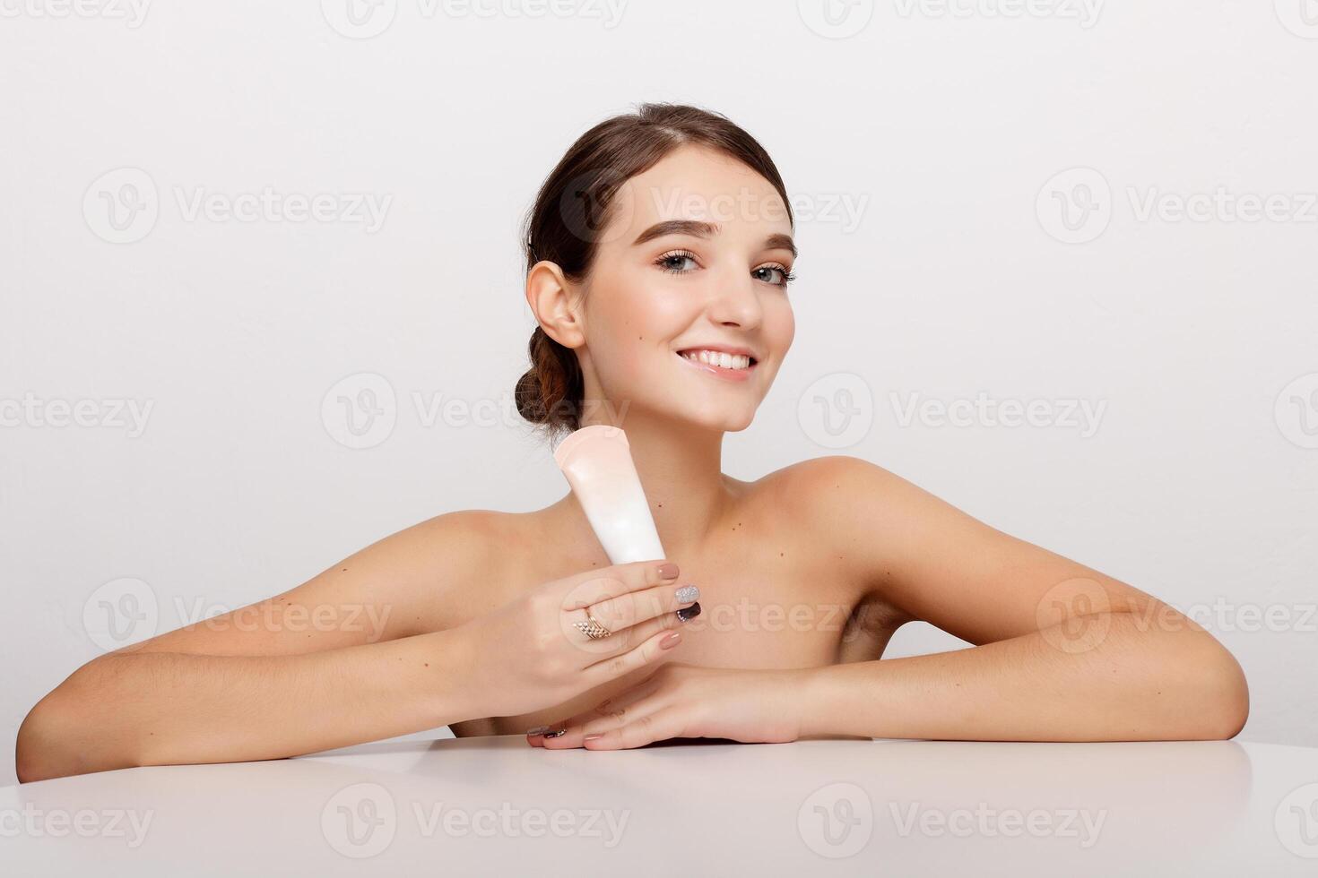 Beauty face of young woman with cosmetic cream on a cheek photo