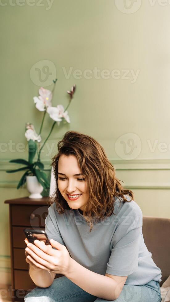 Social Media Enthusiast. Smiling Woman Engaged in Smartphone Chat. Digital Connection. Happy Woman Typing on Smartphone, Socializing. Enjoying Virtual Connections photo