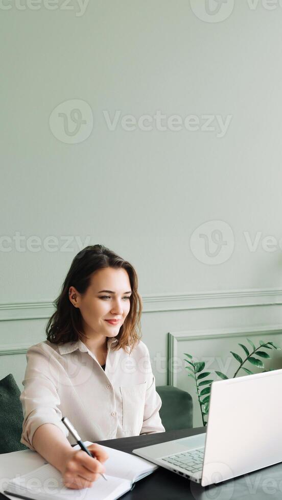 Energetic Millennial Student Engaged. Typing, Video Lesson, and Client Chat on Laptop. Dynamic Millennial Student. Typing, Video Learning, and Client Chat on Laptop with a Smile photo