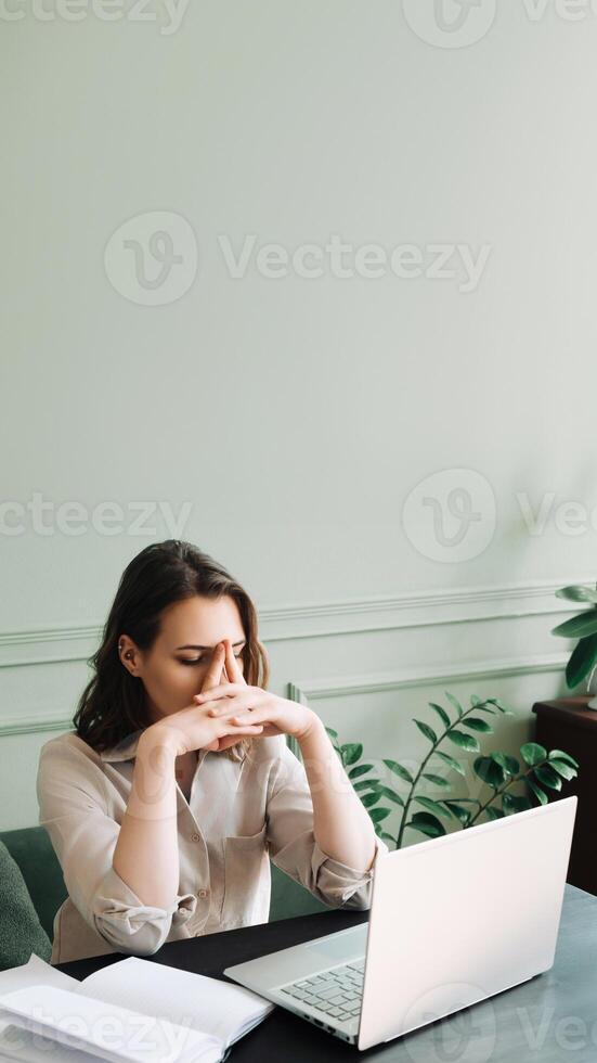 Fatigued and Dismal Young Woman Struggling with Overexertion While Staring at Computer. Weary Young Woman in Distress. Overexerted and Gloomily Contemplating at Her Computer photo