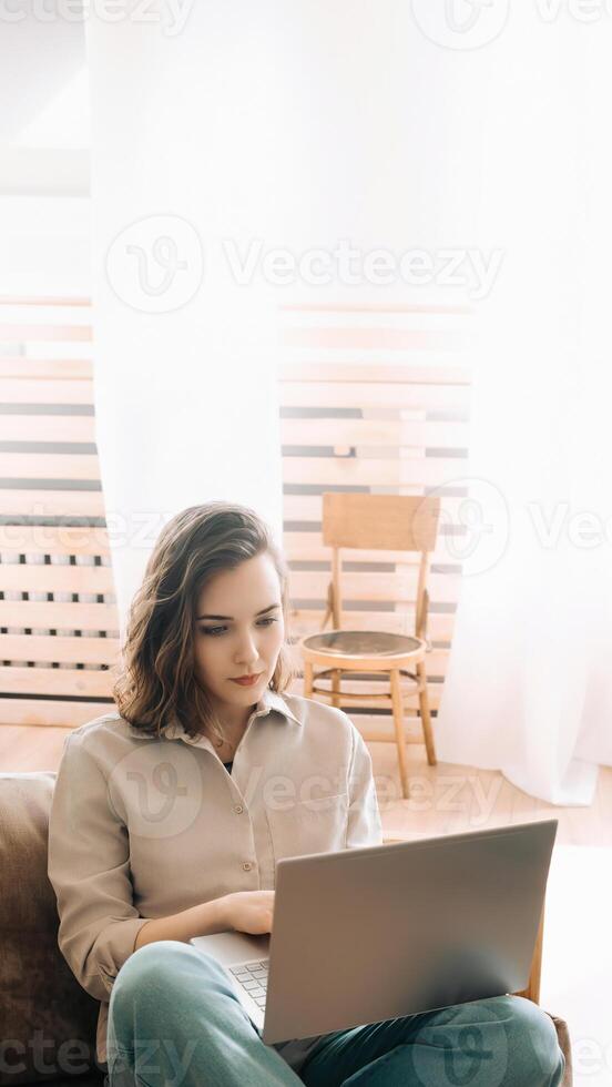 Productive Home Workspace. Woman Typing on Laptop in Living Room. Home Office Vibes. Serious Woman Typing on Laptop in Living Room. photo