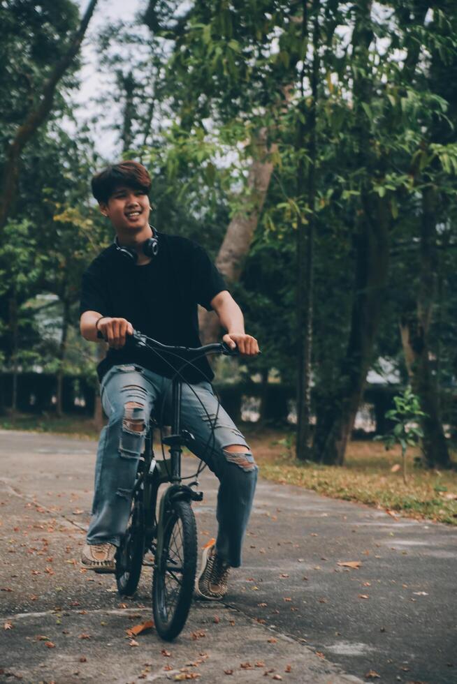 Young handsome bearded man taking a break while travelling the city with his bicycle using his digital tablet looking away thoughtfully photo