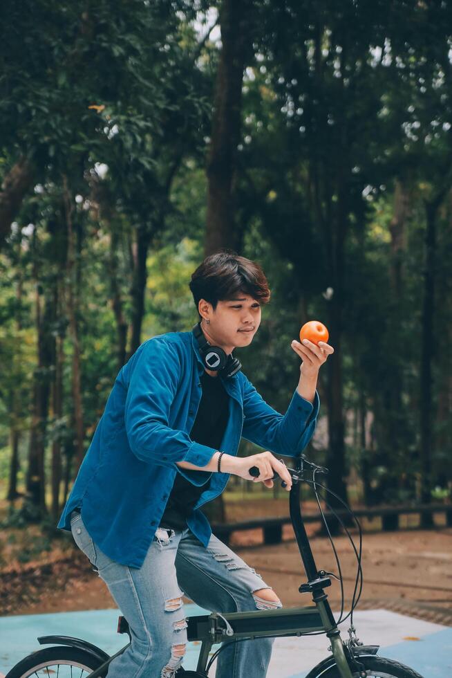 Young handsome bearded man taking a break while travelling the city with his bicycle using his digital tablet looking away thoughtfully photo