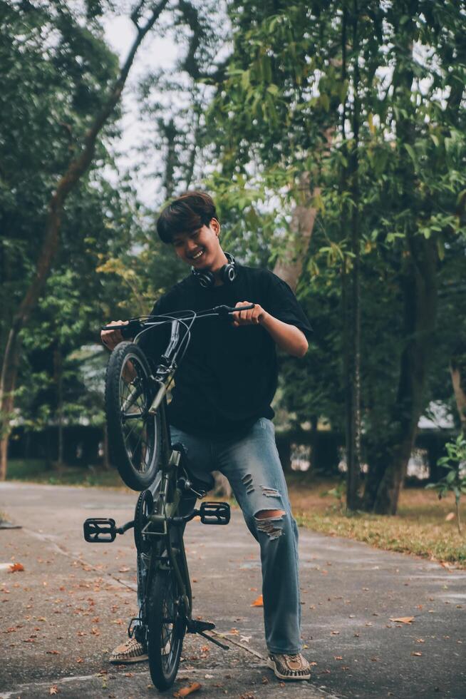 Young handsome bearded man taking a break while travelling the city with his bicycle using his digital tablet looking away thoughtfully photo