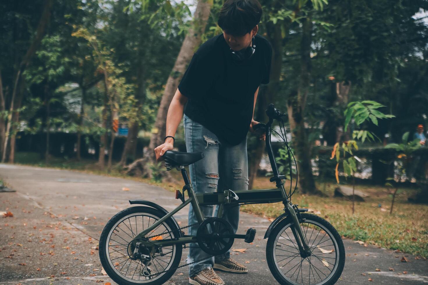 Young handsome bearded man taking a break while travelling the city with his bicycle using his digital tablet looking away thoughtfully photo