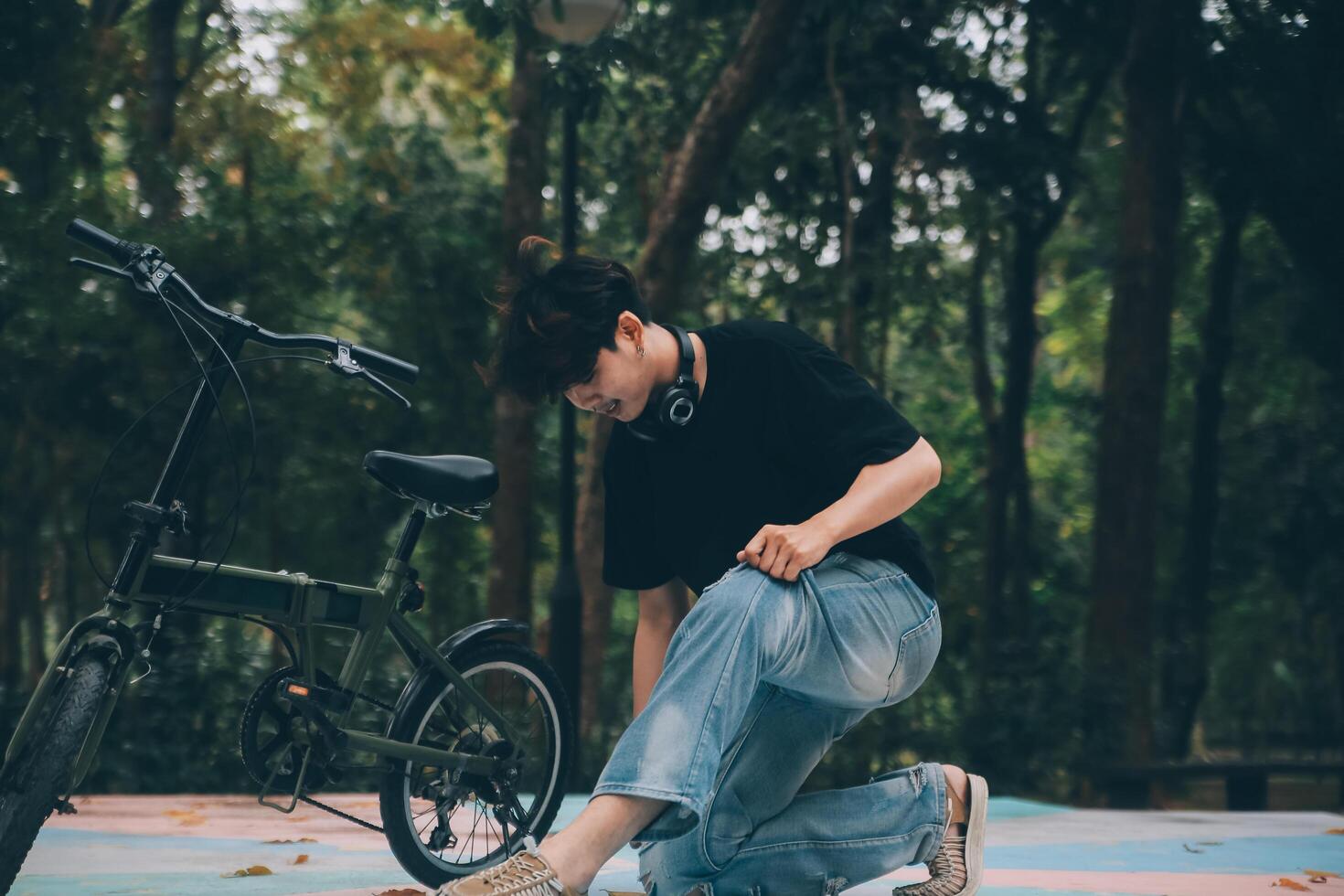 Young handsome bearded man taking a break while travelling the city with his bicycle using his digital tablet looking away thoughtfully photo