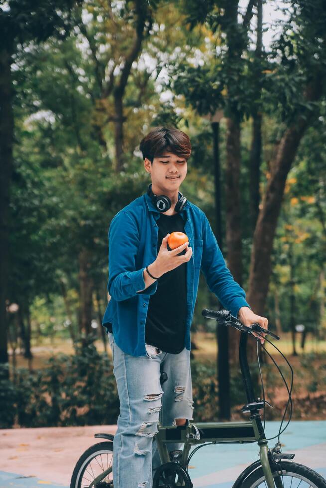 Young handsome bearded man taking a break while travelling the city with his bicycle using his digital tablet looking away thoughtfully photo