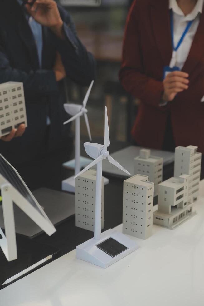 Close-up at tablet, Engineers pointing at tablet with their hands. To jointly design the use of renewable energy with wind and solar energy. Concept of using renewable energy. photo