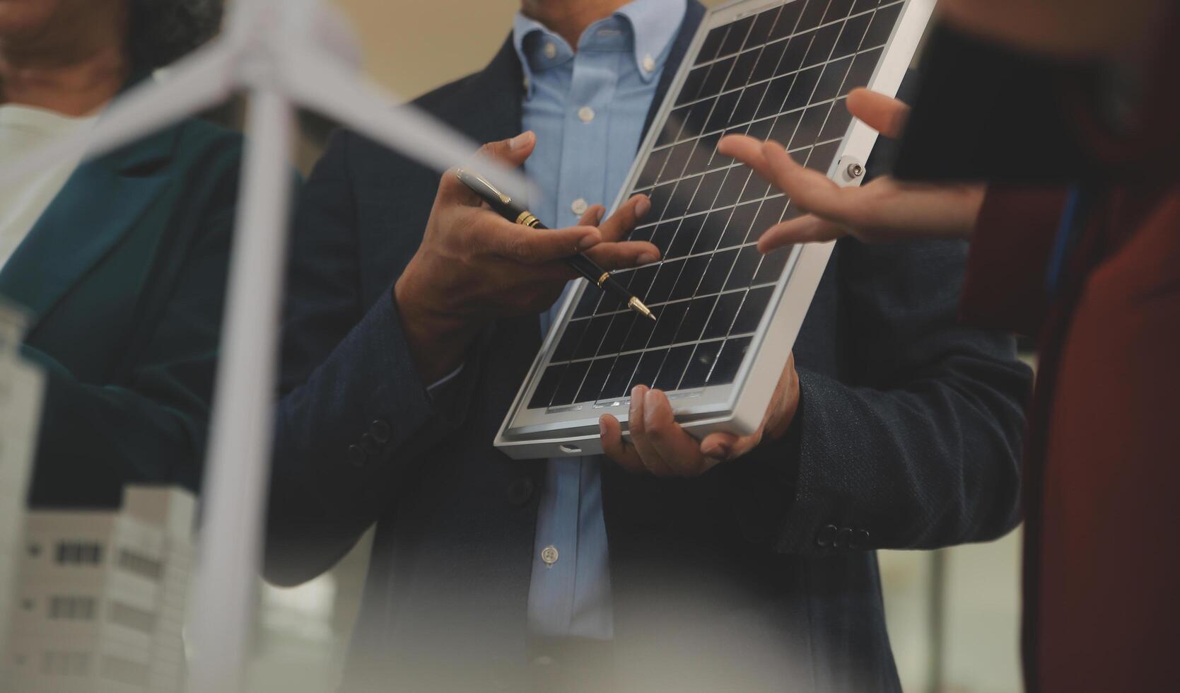 Close-up at tablet, Engineers pointing at tablet with their hands. To jointly design the use of renewable energy with wind and solar energy. Concept of using renewable energy. photo