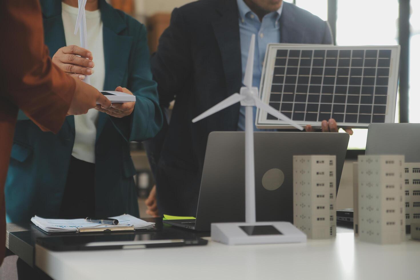 Close-up at tablet, Engineers pointing at tablet with their hands. To jointly design the use of renewable energy with wind and solar energy. Concept of using renewable energy. photo