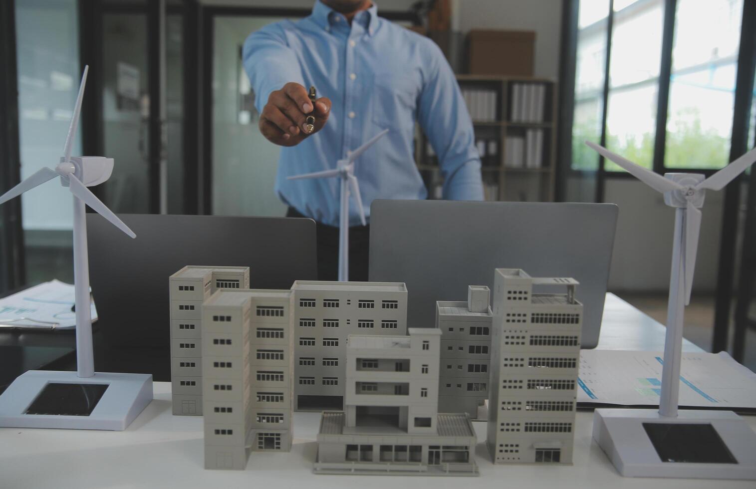 Close-up at tablet, Engineers pointing at tablet with their hands. To jointly design the use of renewable energy with wind and solar energy. Concept of using renewable energy. photo