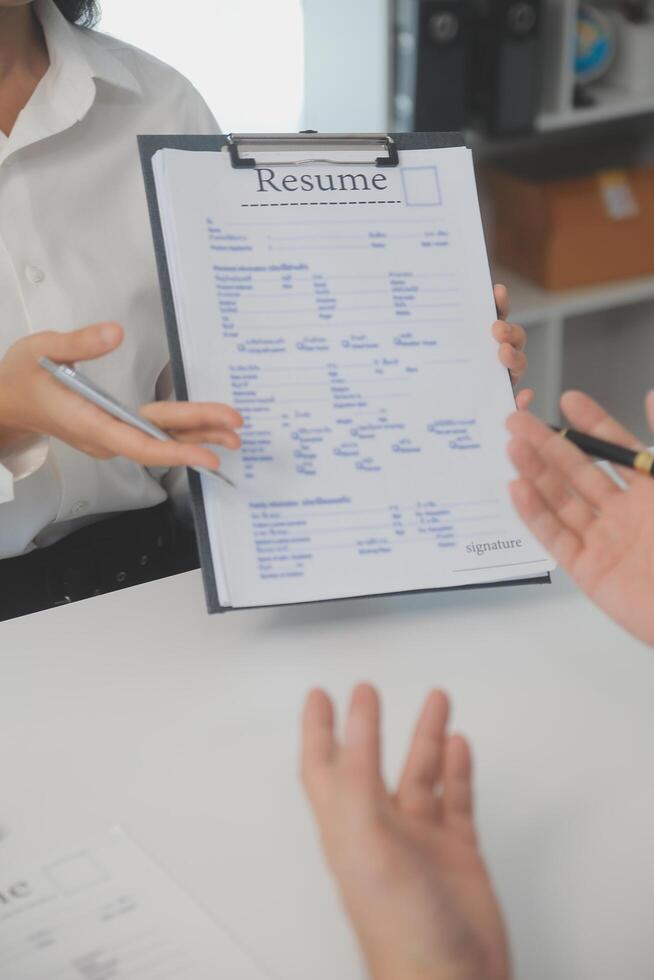 Close up view of job interview in office, focus on resume writing tips, employer reviewing good cv of prepared skilled applicant, recruiter considering application, hr manager making hiring decision photo