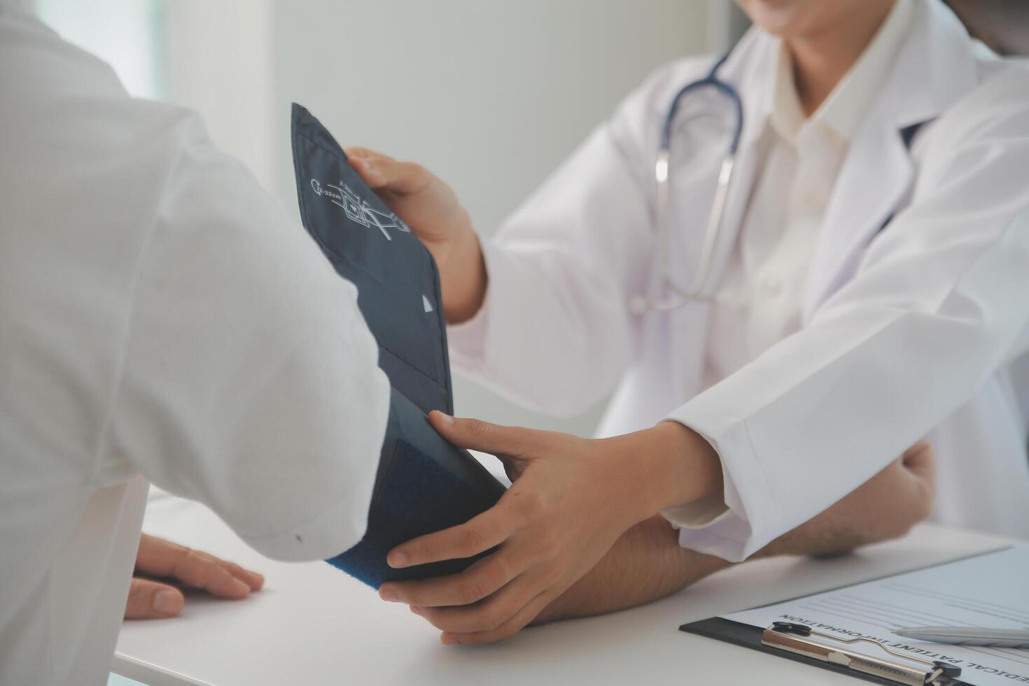 Male doctor uses a blood pressure monitor to check the body pressure and pulse of the patients who come to the hospital for check-ups, Medical treatment and health care concept. photo