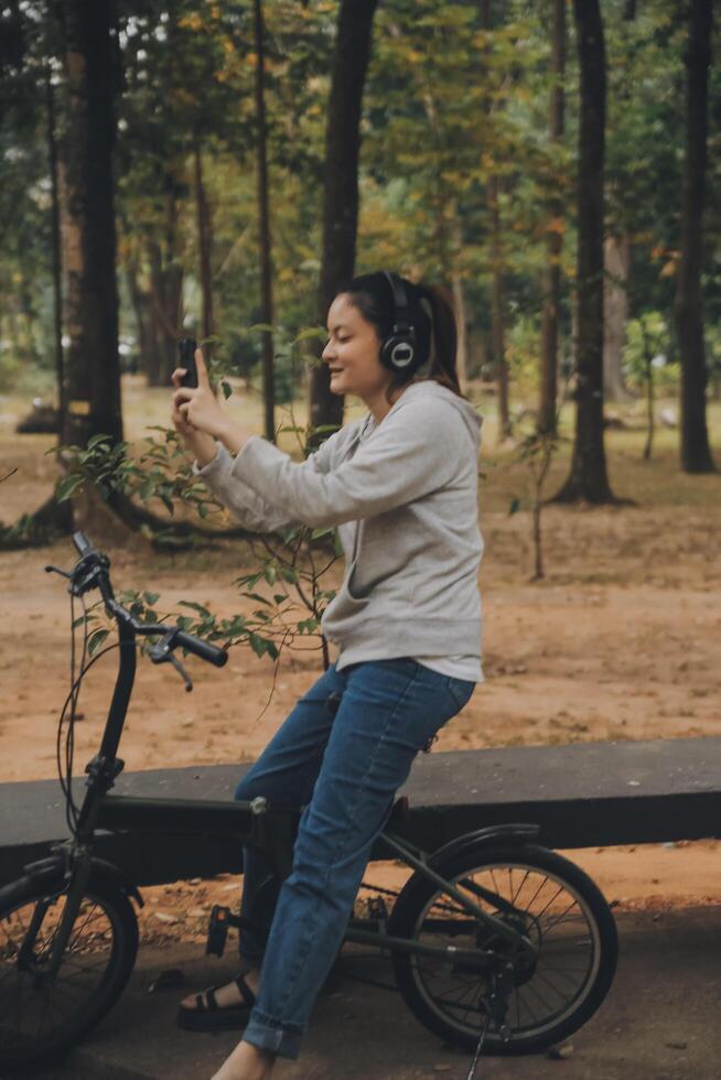 Happy Asian young woman walk and ride bicycle in park, street city her smiling using bike of transportation, ECO friendly, People lifestyle concept. photo