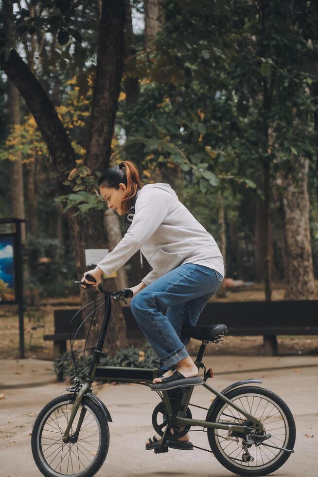 Happy Asian young woman walk and ride bicycle in park, street city her smiling using bike of transportation, ECO friendly, People lifestyle concept. photo