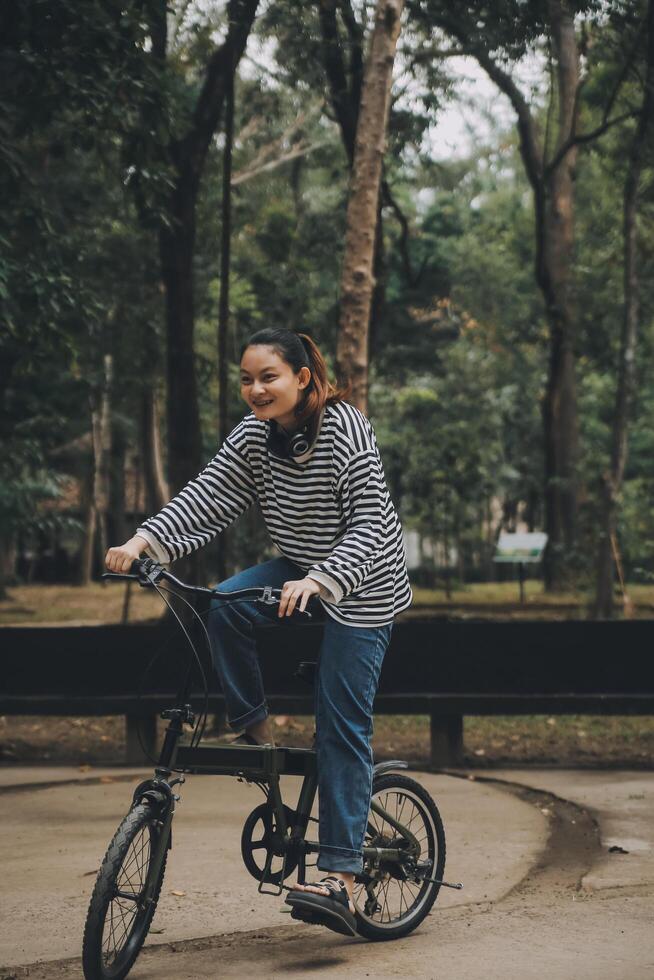 Happy Asian young woman walk and ride bicycle in park, street city her smiling using bike of transportation, ECO friendly, People lifestyle concept. photo