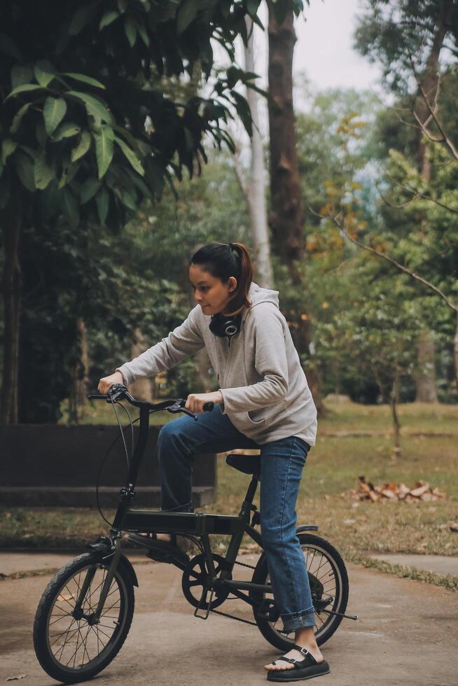 Happy Asian young woman walk and ride bicycle in park, street city her smiling using bike of transportation, ECO friendly, People lifestyle concept. photo