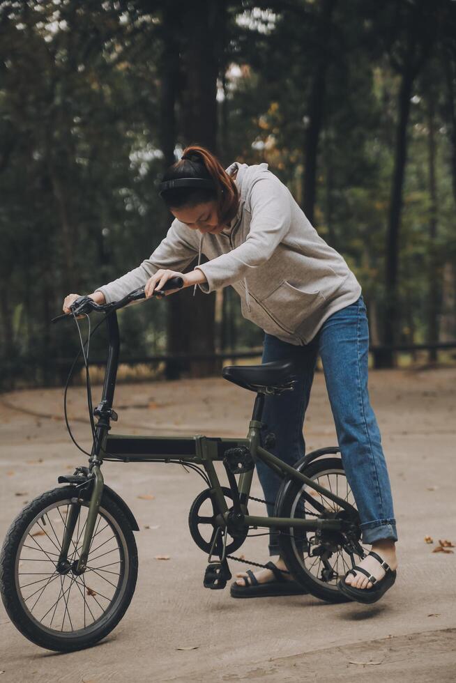 Happy Asian young woman walk and ride bicycle in park, street city her smiling using bike of transportation, ECO friendly, People lifestyle concept. photo