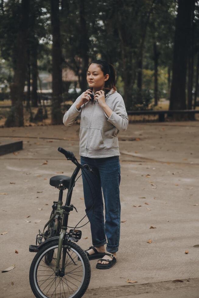 Happy Asian young woman walk and ride bicycle in park, street city her smiling using bike of transportation, ECO friendly, People lifestyle concept. photo