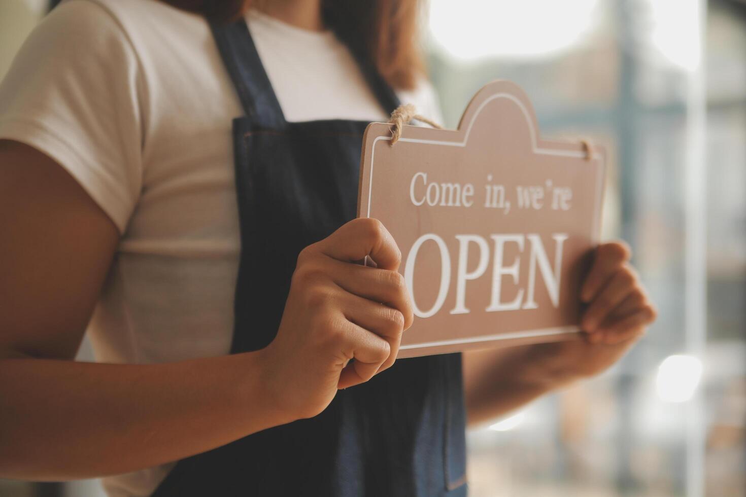 Startup successful small business owner sme beauty girl stand with tablet smartphone in coffee shop restaurant. Portrait of asian tan woman barista cafe owner. SME entrepreneur seller business concept photo
