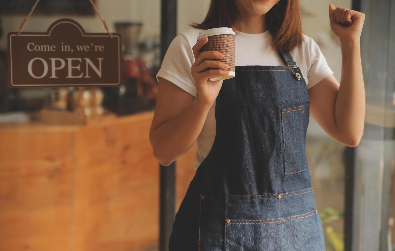 Startup successful small business owner sme beauty girl stand with tablet smartphone in coffee shop restaurant. Portrait of asian tan woman barista cafe owner. SME entrepreneur seller business concept photo