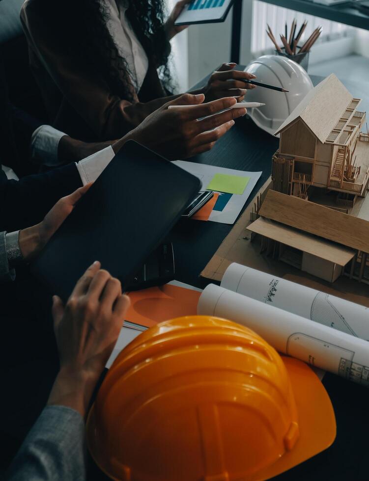 reunión de trabajo en equipo de ingenieros, trabajo de dibujo en la reunión de planos para el trabajo del proyecto con un socio en la construcción de modelos y herramientas de ingeniería en el concepto de sitio de trabajo, construcción y estructura. foto