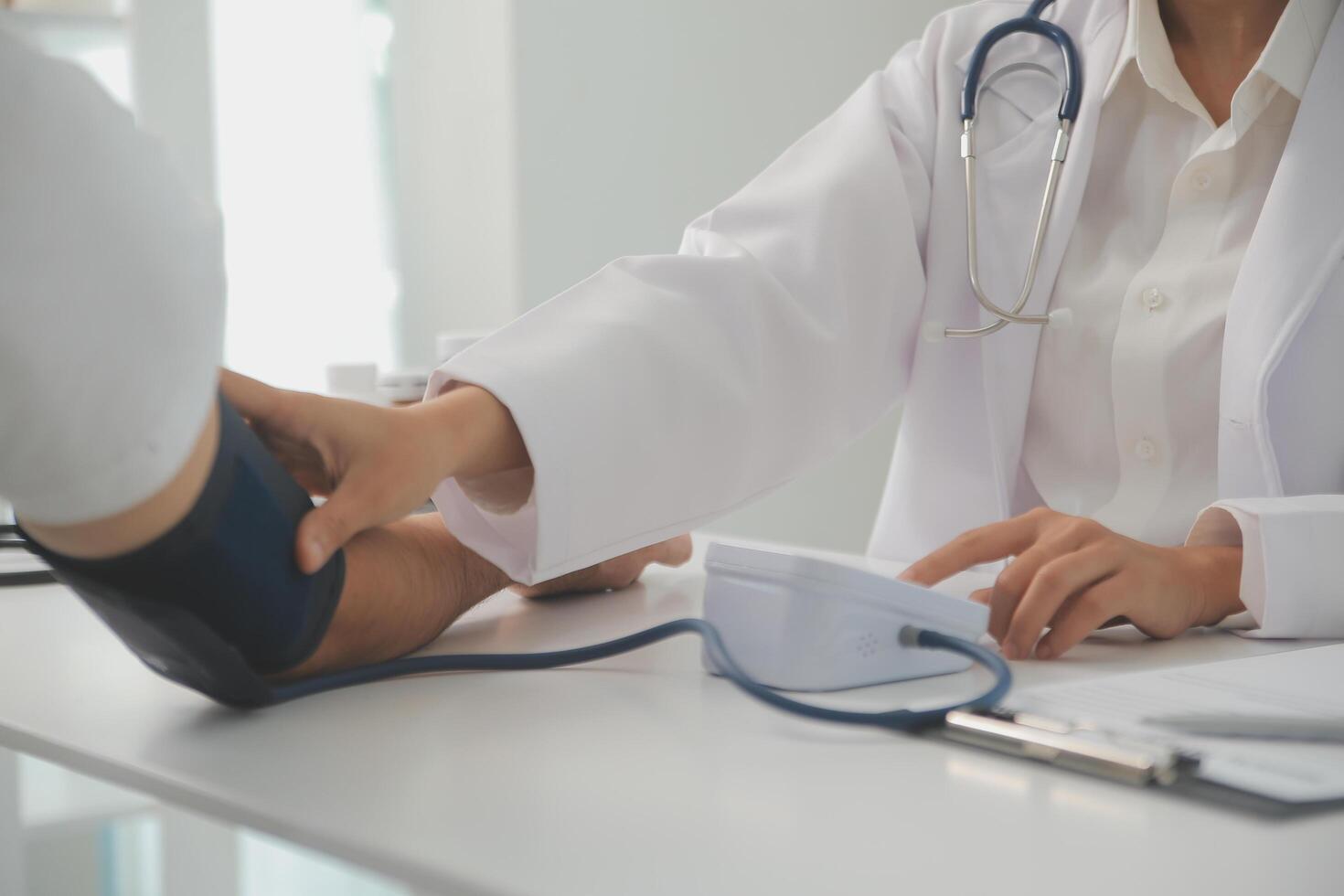 Male doctor uses a blood pressure monitor to check the body pressure and pulse of the patients who come to the hospital for check-ups, Medical treatment and health care concept. photo